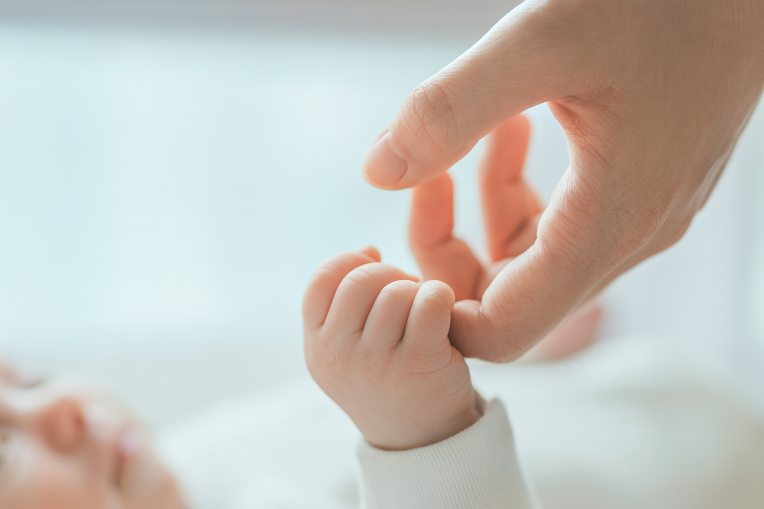 Parent holding baby's hand